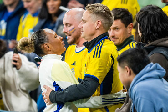 Madelen Janogy of Sweden hugs a man in the stands