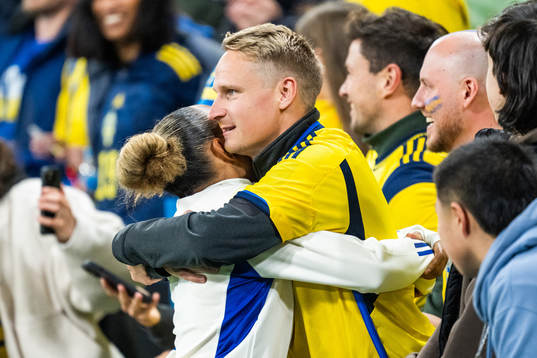 Madelen Janogy of Sweden hugs a man in the stands