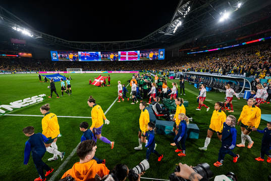 Players of Australia and of Denmark enter the pitch