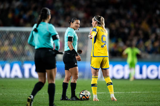 referee Edina Alves and Kosovare Asllani of Sweden