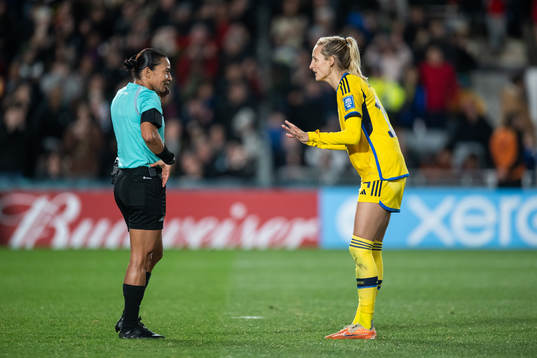 referee Edina Alves and Nathalie Björn of Sweden