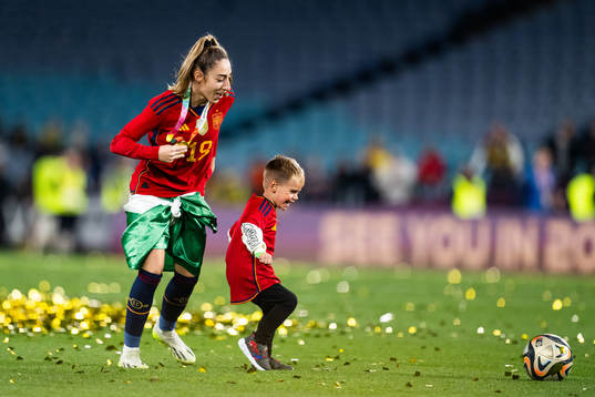 Olga Carmona of Spain plays football with a child as she