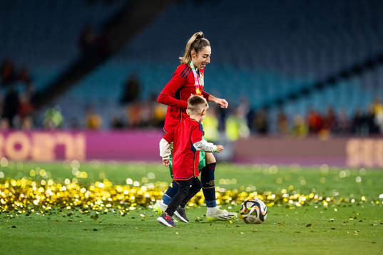 Olga Carmona of Spain plays football with a child as she