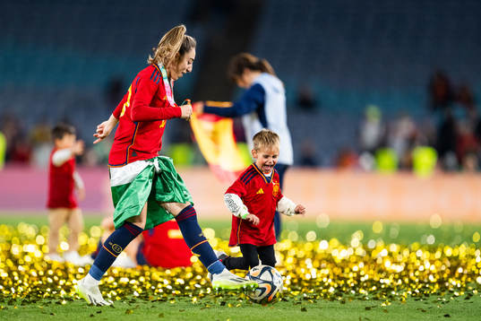 Olga Carmona of Spain plays football with a child as she