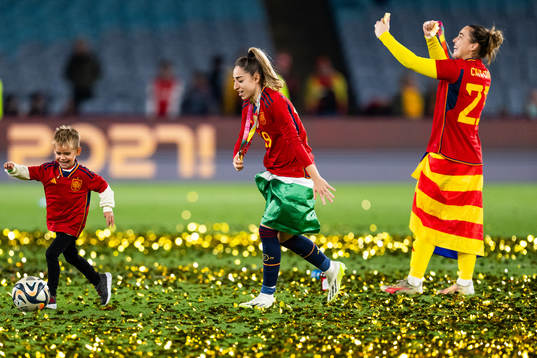 Olga Carmona of Spain plays football with a child as she