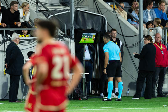 Referee Filip Glova reviews a possible penalty