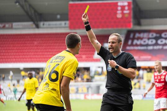 Domare Richard Sundell delar ut ett gult kort till