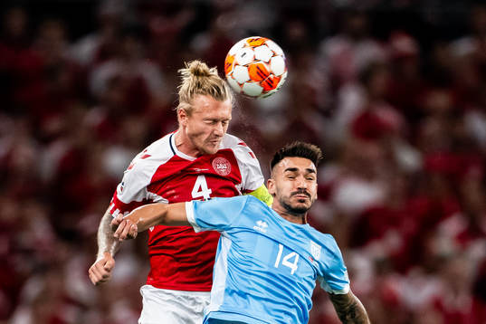 Simon Kjær of Denmark and Fabio Tomassini of San Marino