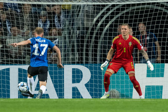 Martin Miller of Estonia and goalkeeper Robin Olsen of