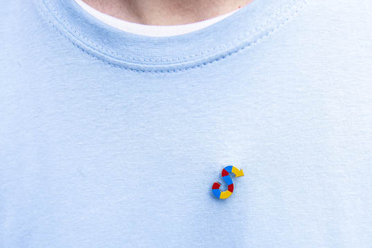 En pin med ett S i Djurgårdens färger på en t-shirt