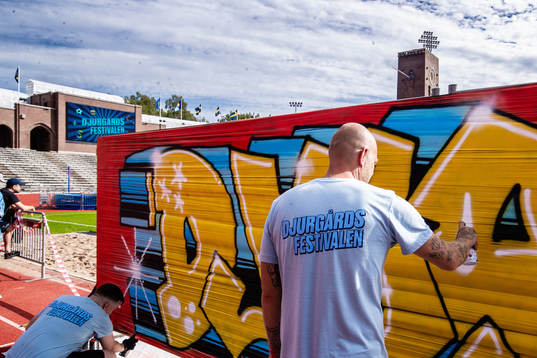 Personal målar på ett graffitiplank