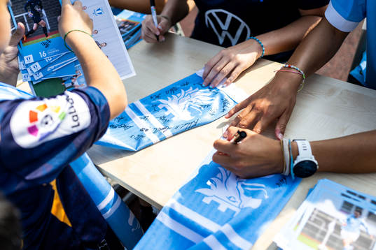 Spelare från Malmö FFs damlag skriver autografer