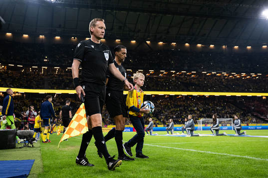 Referee Serdar Gözübüyük and a mascot