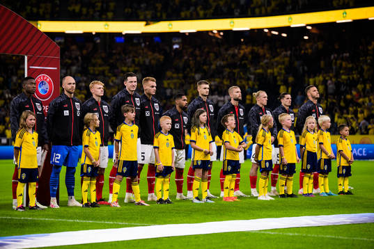 Swedish mascots in front of players of Austria