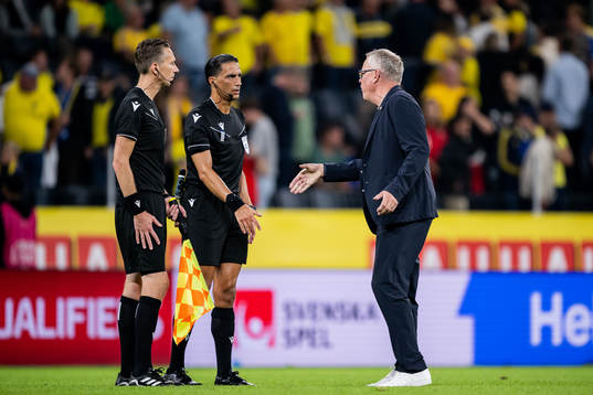 Referee Serdar Gozubuyuk and Head coach Janne Andersson of