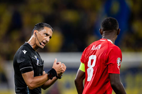 Referee Serdar Gozubuyuk and David Alaba of Austria