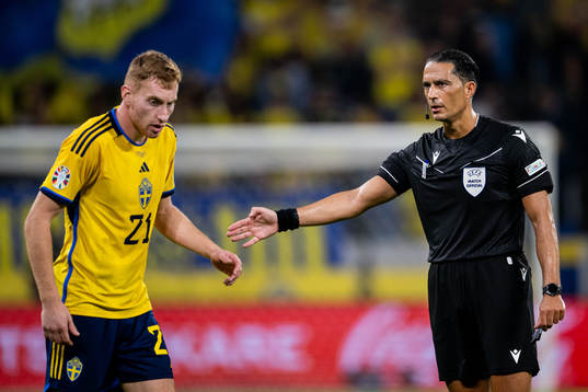 Dejan Kulusevski of Sweden and referee Serdar Gozubuyuk
