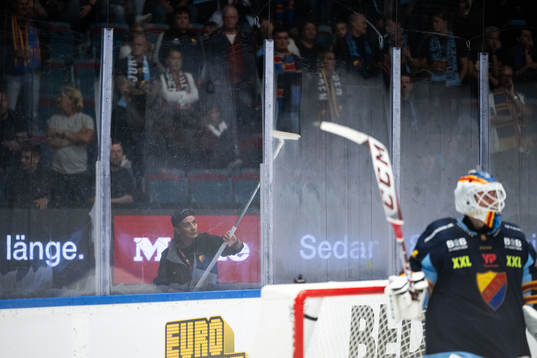 En funktionär skrapar kondens från plexiglasen