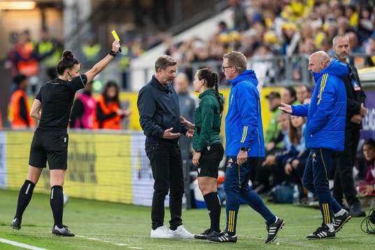 Referee Rebecca Welch gives a yellow card for someone at
