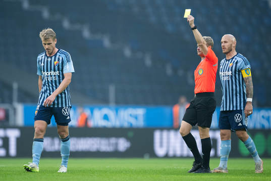 Domare Fredrik Klitte delar ut ett gult kort till
