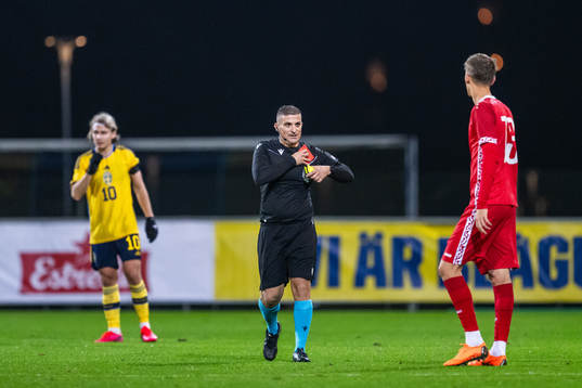 Referee Trustin Farrugia Cann picks up cards from his pocket