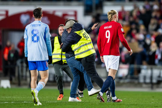 A steward is taking care of a pitch invader