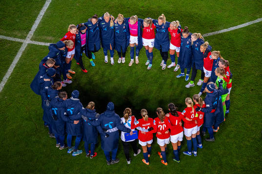 Players and staff of Norway gather in a circle