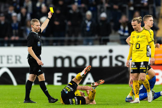 Domare Fredrik Klitte delar ut en varning till IFK