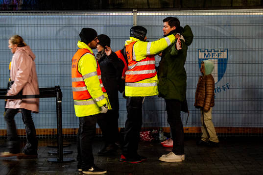 Spectators is visited by security personel outside of the