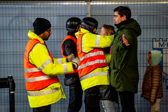Spectators is visited by security personel outside of the