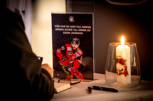 Besökare skriver i en kondoleansbok framför bortgångne