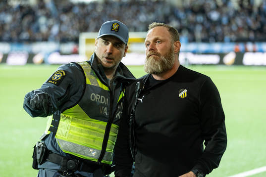 En ordningsvakt i samtal med Häckens säkerhetsansvarige