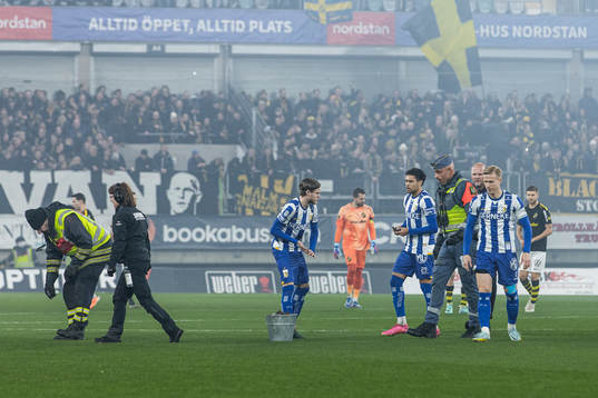 Spelare och personal plockar avfall från pryoteknik på