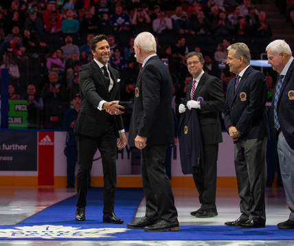 Henrik Lundqvist receives his blazer from Lanny McDonald