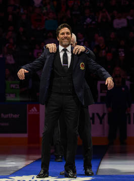 Henrik Lundqvist receives his blazer from Lanny McDonald