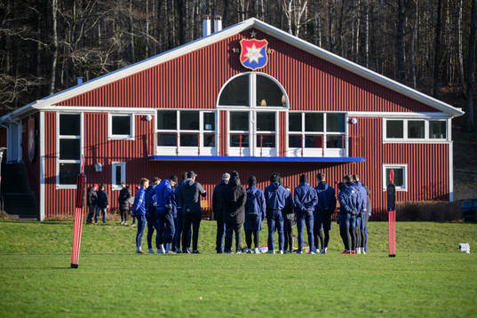 Spelare och tränare samlas framför ÖIS-gården