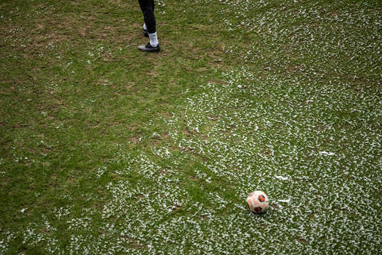 Feet with football boots and snow