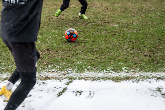 Feet of players is seen going for a ball