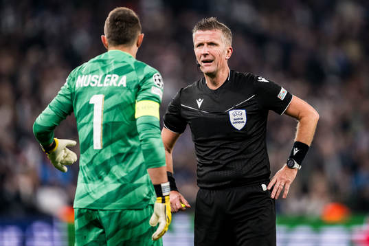 Referee Daniele Orsato and goalkeeper Fernando Muslera of