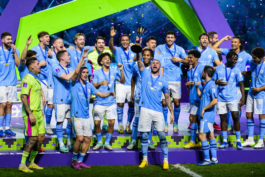Players of Manchester City celebrate with the trophy