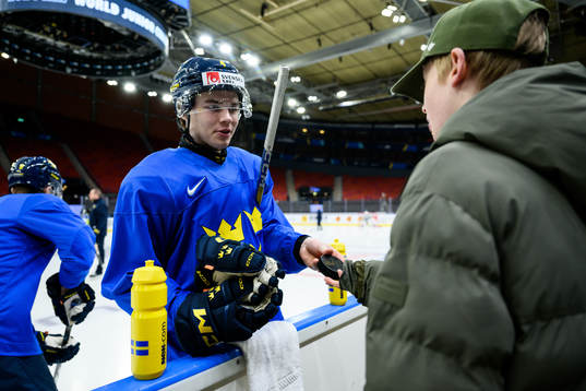 Axel Sandin-Pellikka of Sweden giveas a puck to a supporter