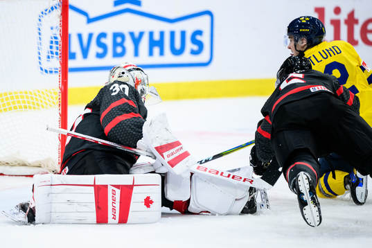 Noah Östlund of Sweden and goaltender Mathis Rousseau of