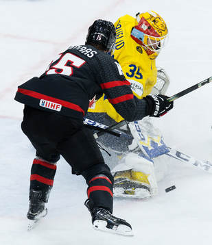 Matthew Poitras of Canada goaltender Hugo Hävelid of Sweden