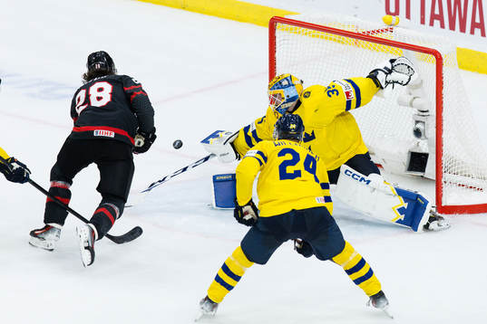 Goaltender Hugo Hävelid of Sweden and Conor Geekie of
