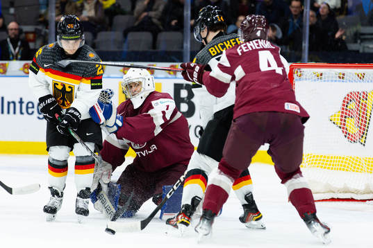 Goaltender Deivs Rolovs of Latvia and Moritz Elias and