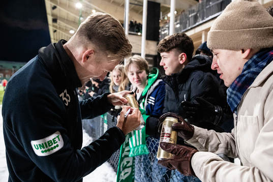 Fredrik Hammar skriver sin autograf på en ölburk