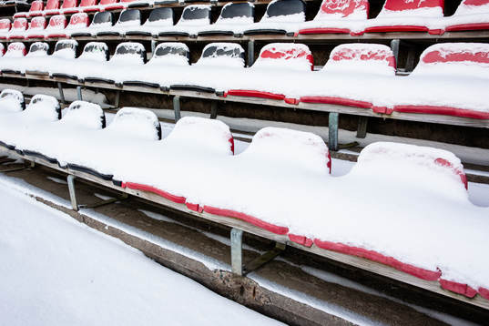 Snö över stolar på läktare på Grimsta IP