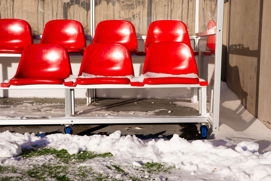 Stolar med snö i ett avbytarbås