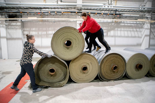 Föräldrarna Sara Rautio och Elli Massoe lägger konstgräs