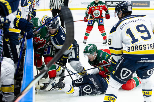 Kamp om pucken vid sargen mellan Frölundas Nicklas Lasu,